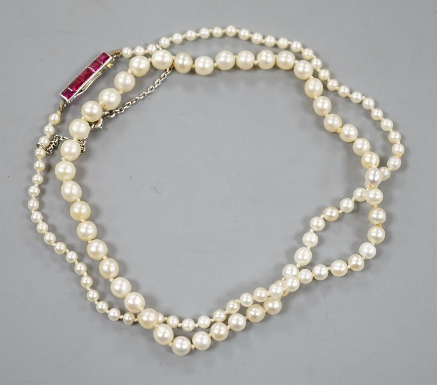 An early 20th century single strand graduated pearl necklace(pearls have not been tested as to whether or not they are natural), five stone ruby set yellow metal clasp, 44cm, gross weight 8.7 grams